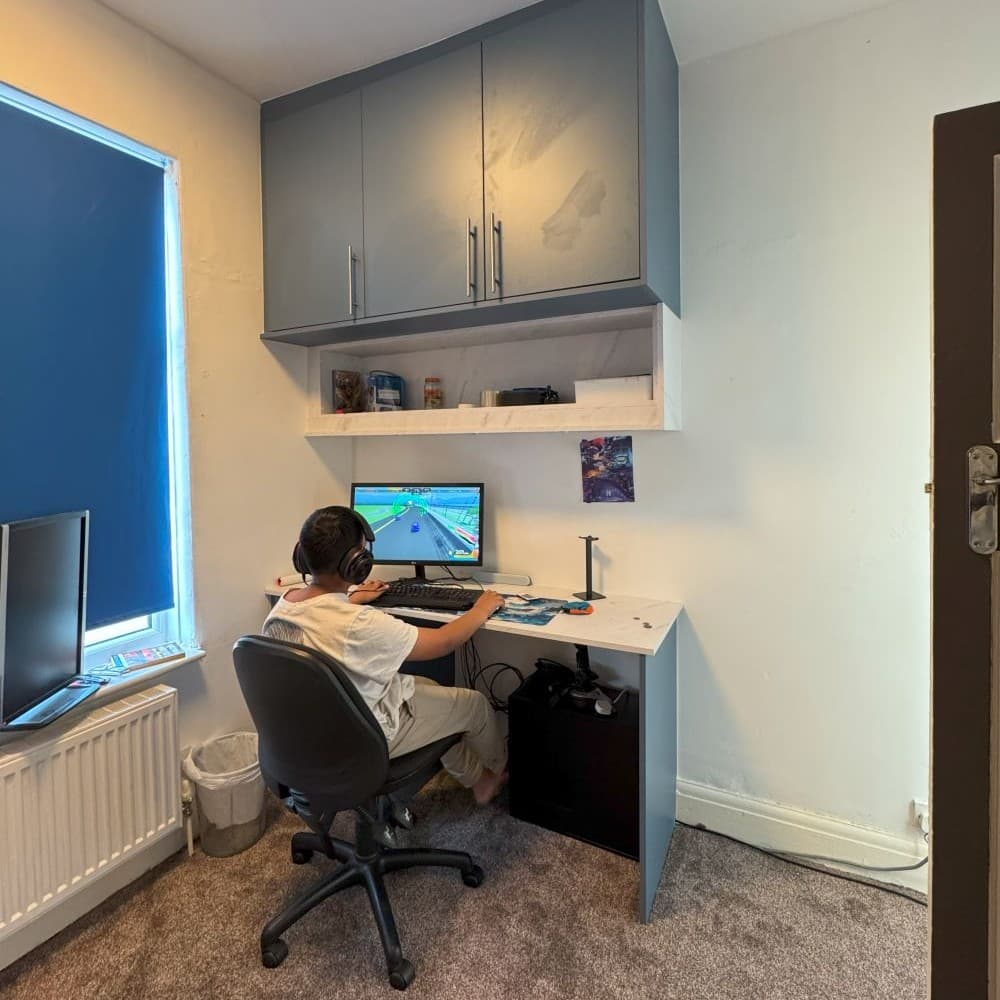 Custom fitted desk and cabinetry for home office workspace with overhead storage