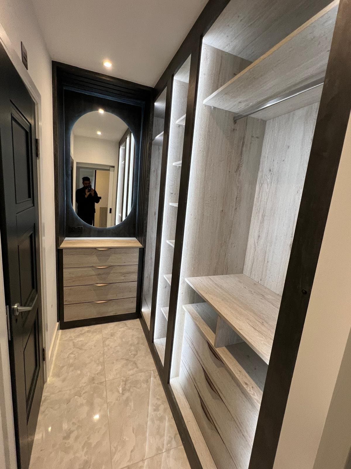 Bespoke walk-in wardrobe with illuminated shelving in a Manchester home